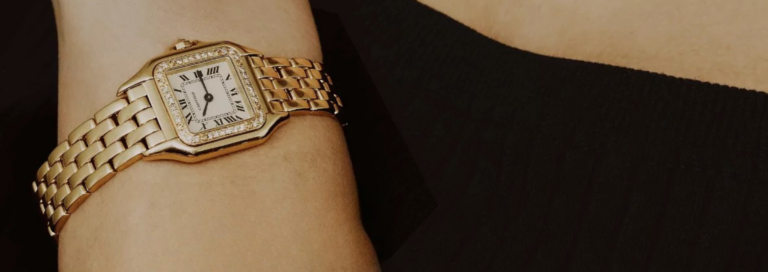Goldene Cartier-Armbanduhr mit Diamantbesatz am Handgelenk als Symbol für luxuriösen Schmuck und hochwertige Uhren